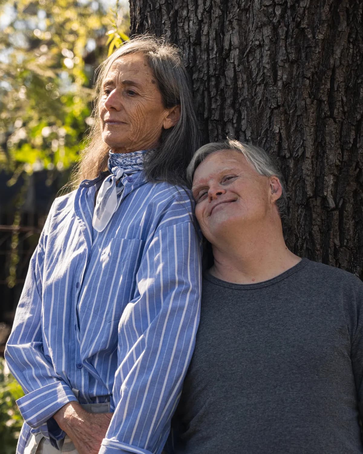 Dos personas abrazadas a la sombra de un árbol